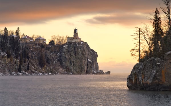 A photo taken by Ryan Tischer of Split Rock Lighthouse from a distance on a winter's evening.